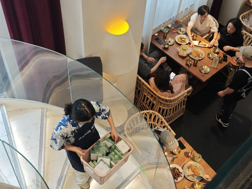 Aman resort staff member providing personalized tea ceremony service to guest in private villa, exemplifying the brand's exceptional hospitality standards