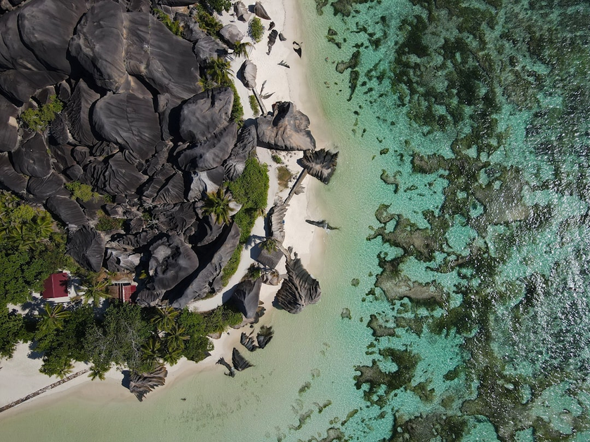 Aerial view of exclusive private island luxury resort in Seychelles with white sand beaches, luxury villas, and turquoise ocean waters