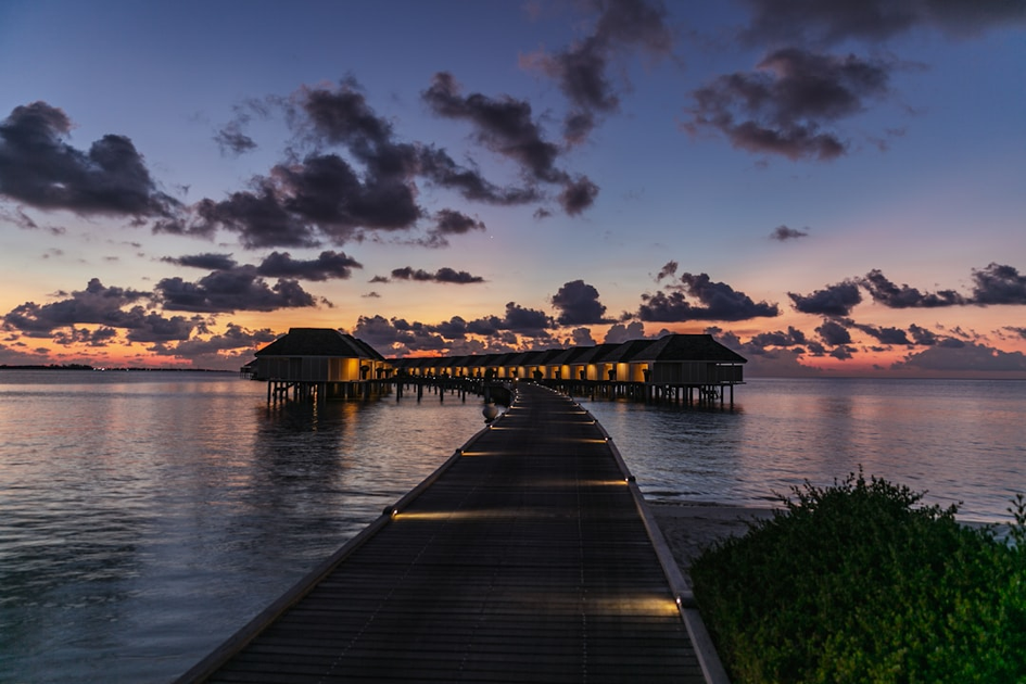 Luxury overwater bungalow with private infinity pool at sunset at a five-star all-inclusive resort