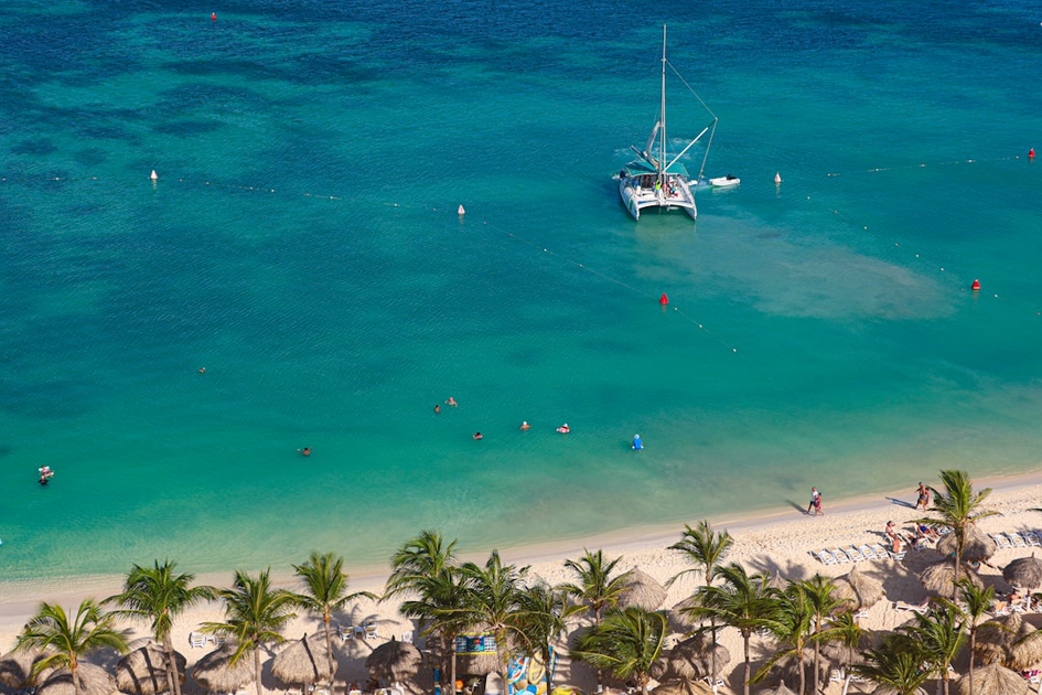 Exclusive Caribbean private island beach with white sand, turquoise waters, palm trees and luxury cabanas